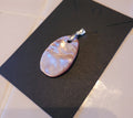 Pearl pendant on a black card with a white tiled background